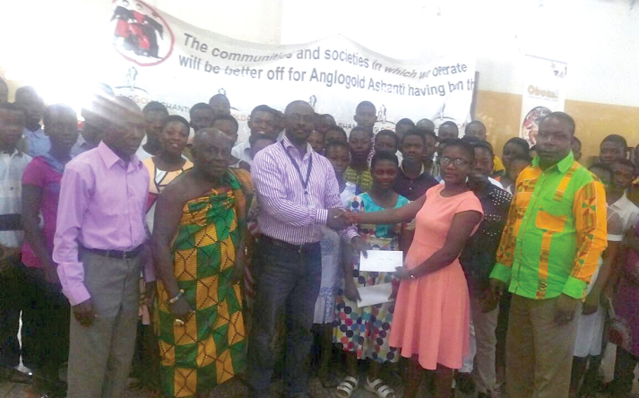  Nana Ampofo Bekoe presenting one of the cheques to a beneficiary, Getrude Amoah of Adventist Girls, Ntonsu. Looking on are Mr Anthony Maxwell Amoako (right), Nana Opoku Ababio (in cloth) and beneficiaries of the educational grant